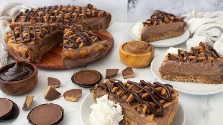 Peanut butter chocolate Polar Pizza on wooden board with slices on plates