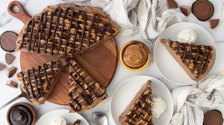 Peanut butter chocolate ice cream cake on wooden board and slices on plates