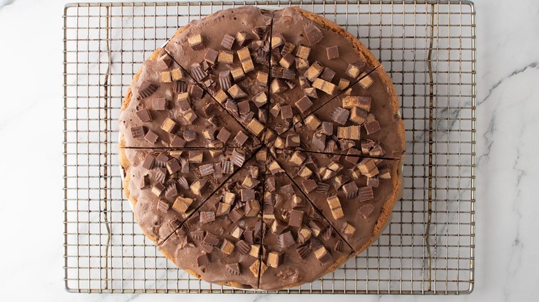 Chocolate peanut butter ice cream cookie pizza sliced on wire rack