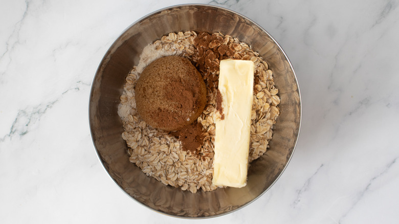 butter, brown sugar, and oats in a metal bowl