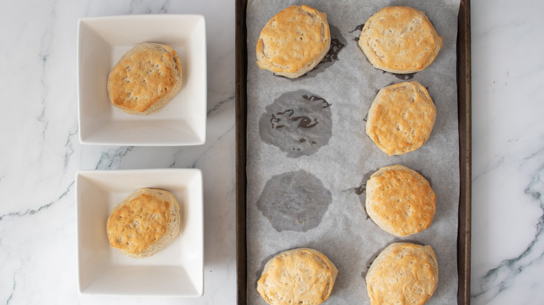 biscuits in two square white bowls next to a pan of biscuits