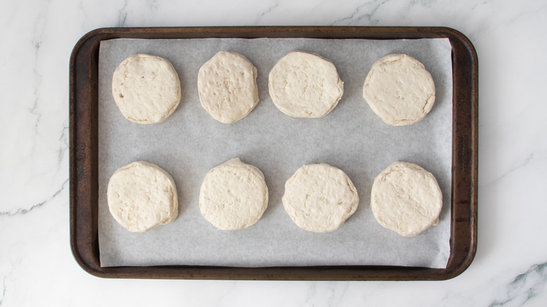 raw biscuit dough circles in a baking pan