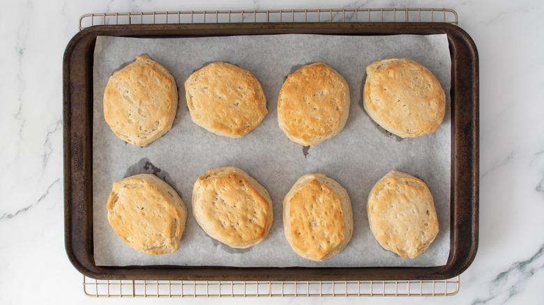 biscuits in a baking pan sitting on top of a wire rack