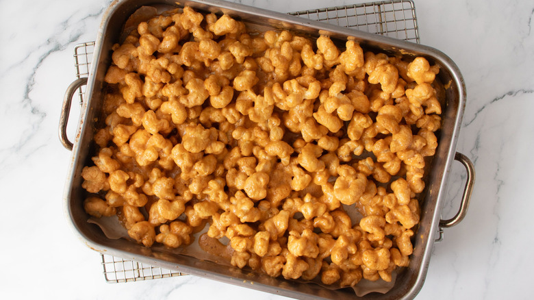 Caramel coated puffcorn in roasting pan on wire rack