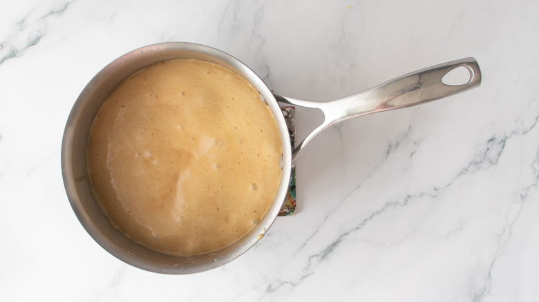 Foamy caramel mixture in saucepan