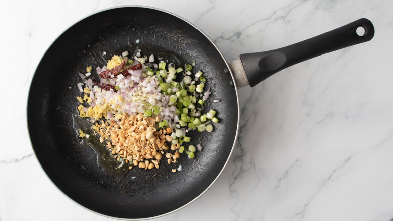 Minced aromatics and peanuts in pan
