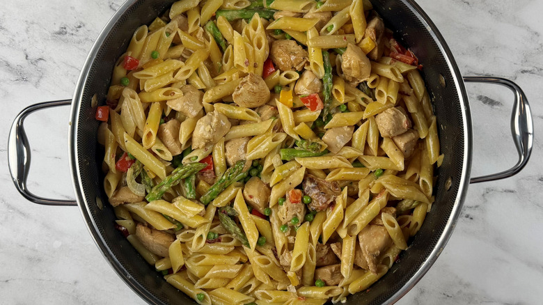 vegetables, chicken, noodles, and sauce in a pot