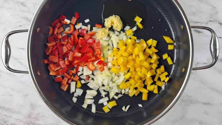 chopped raw vegetables in a black frying pan