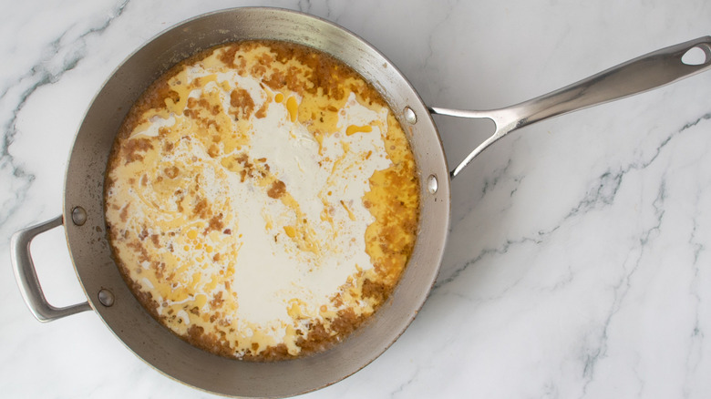 Unmixed broth and cream mixture in skillet