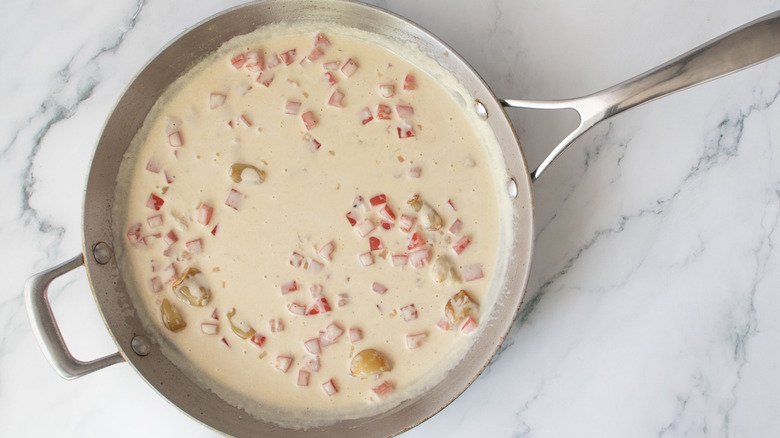 Creamy sauce with tomatoes and garlic in skillet