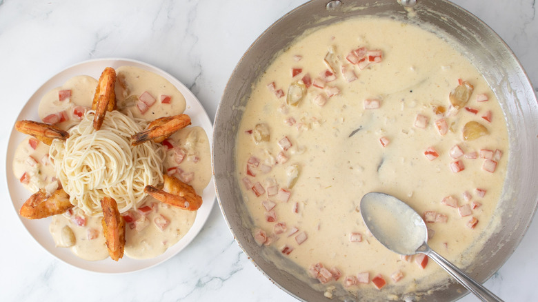 Shrimp scamp on plate next to cream sauce in skillet