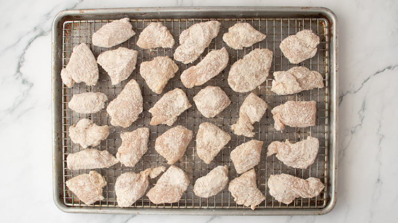 floured chicken pieces in a pan