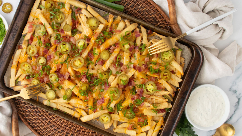 Chili's Texas cheese fries on baking sheet next to bowl of ranch