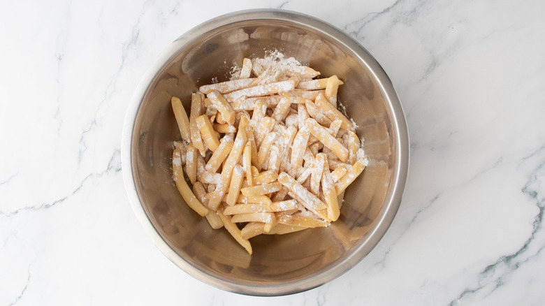 Frozen fries with cornstarch in bowl