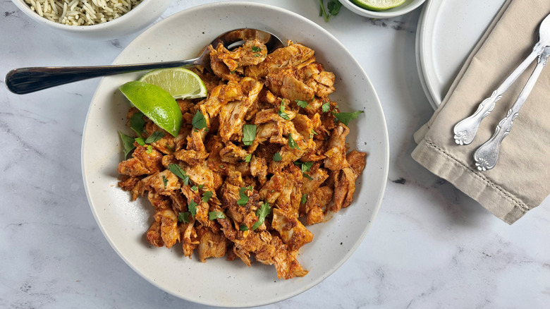 Chicken al pastor with lime wedges in bowl