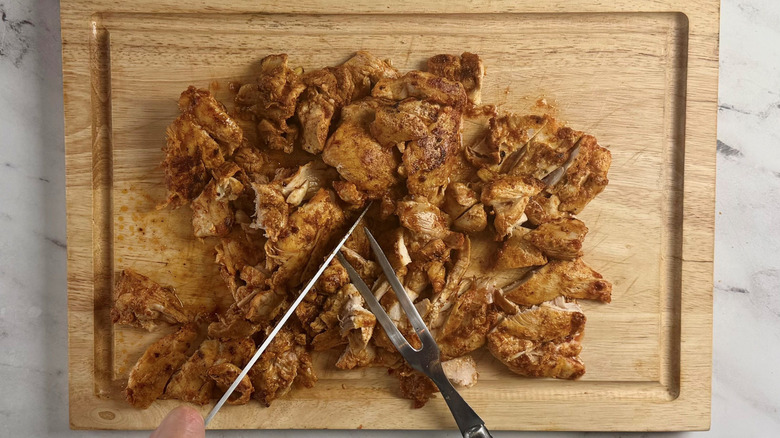 Slicing chicken on wooden board