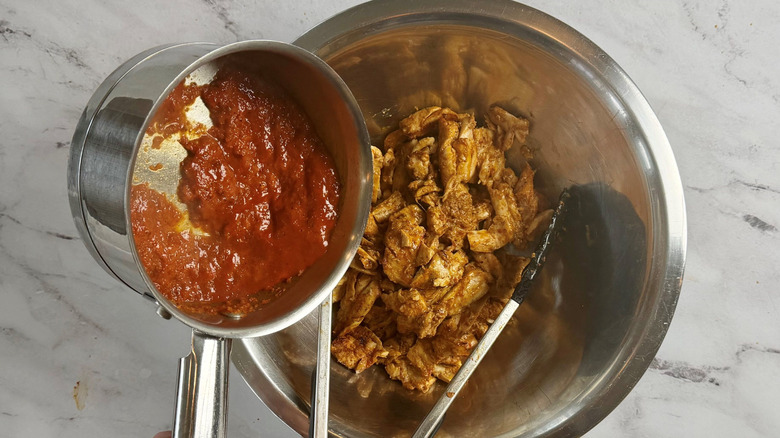 Marinade pouring into bowl with chicken
