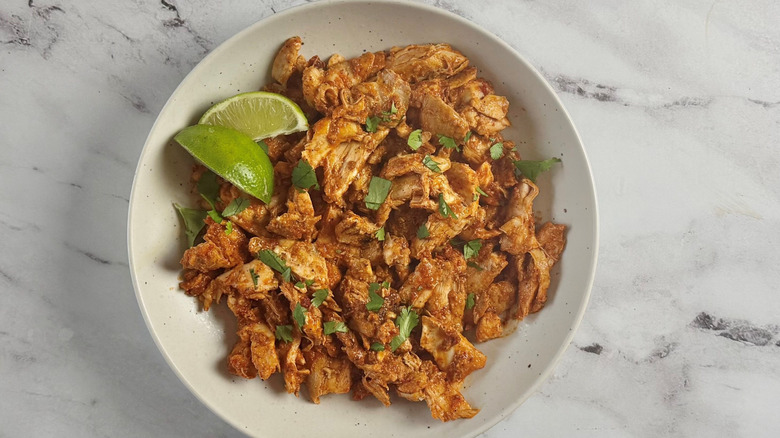 Chicken al pastor with herbs and lime wedges