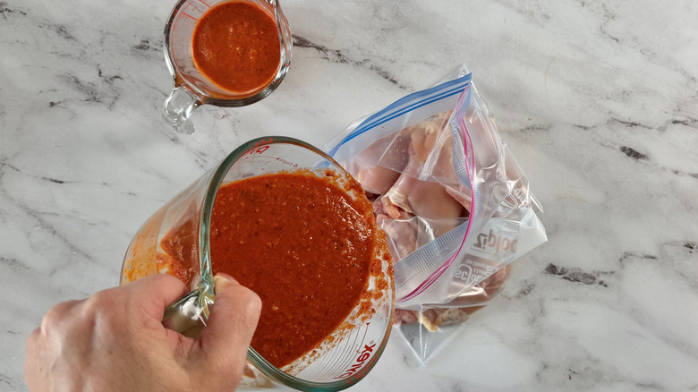 Marinade pouring into bag of chicken thighs