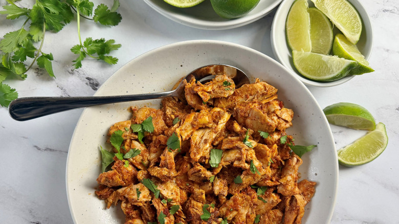 Chicken al pastor with herbs and lime wedges