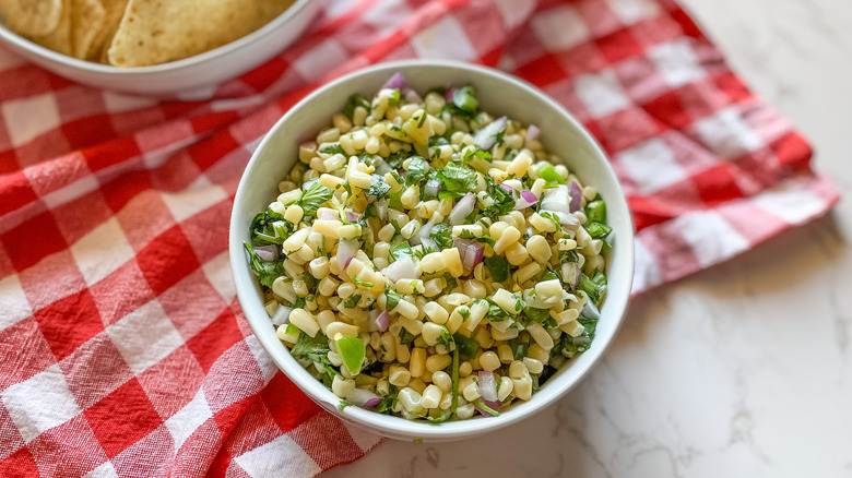 bowl of corn salsa and tortilla chips in background