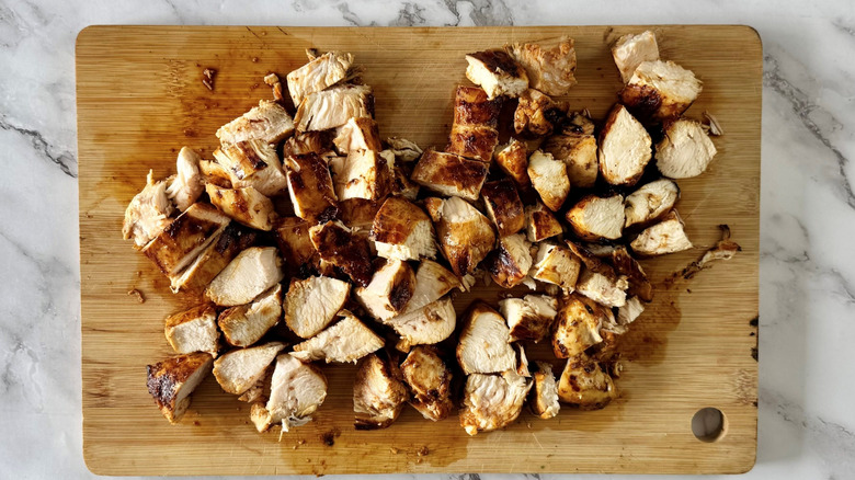 Diced chicken on wooden cutting board