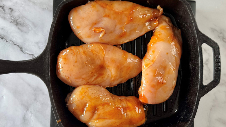 Raw chicken breasts in grill pan