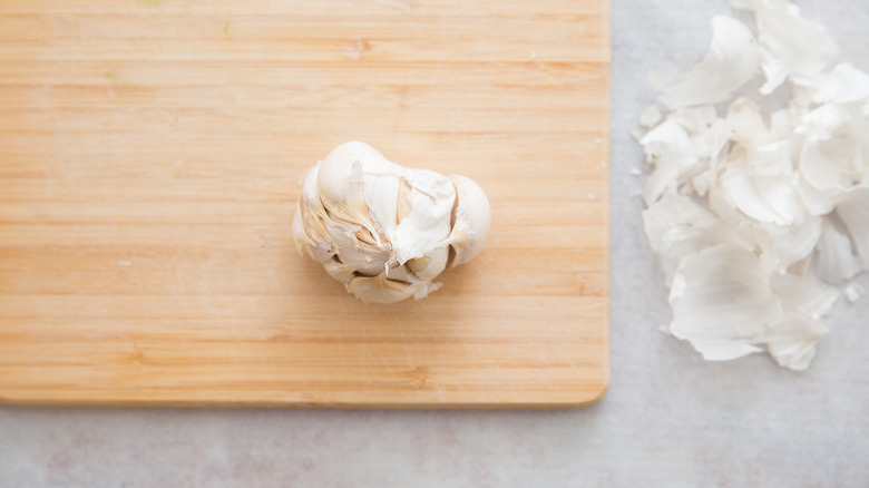 partially peeled garlic on board