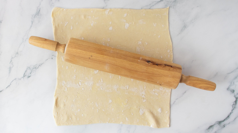 Puff pastry sheet with rolling pin on top