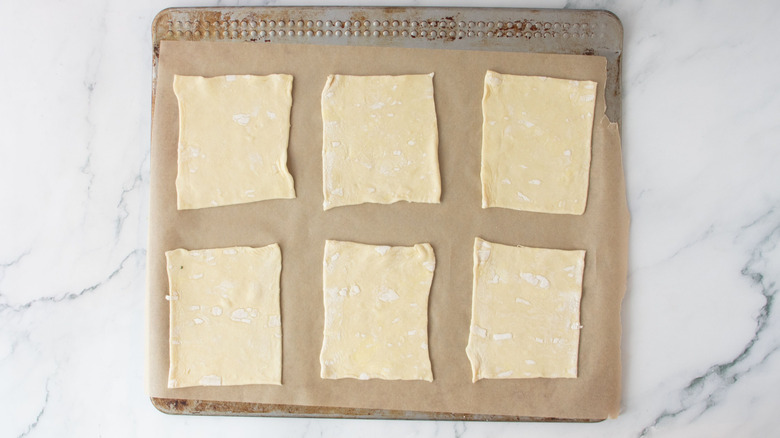 Puff pastry squares on baking sheet