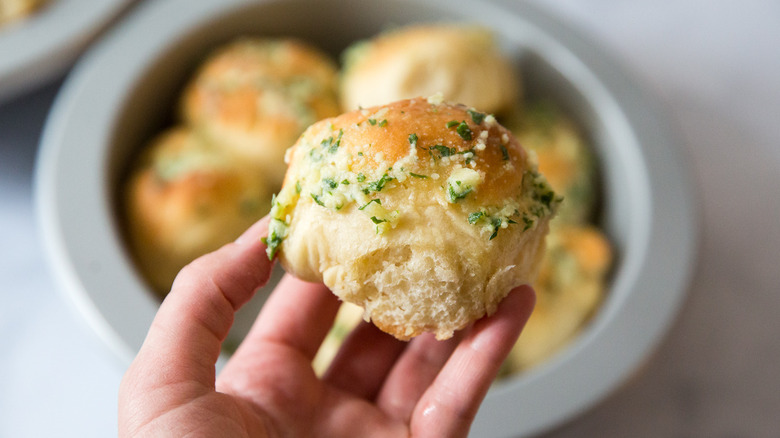 hand holding Parmesan garlic dinner roll