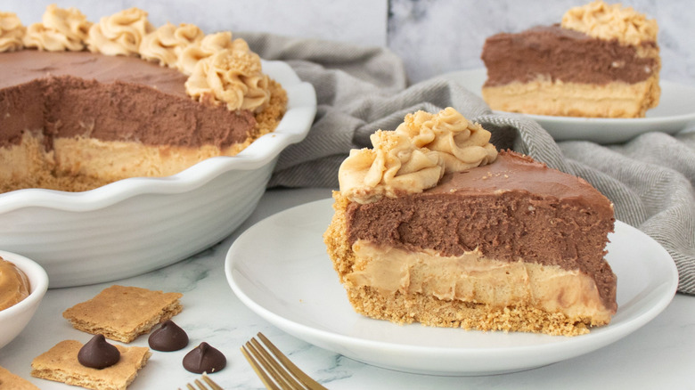 Slices of chocolate peanut butter pie with whole pie in back