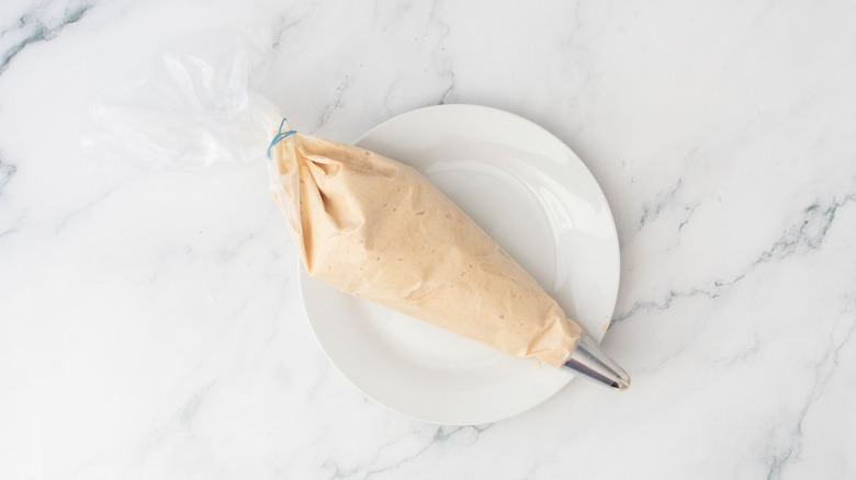 Peanut butter mousse in piping bag on plate