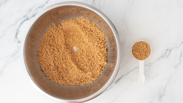 Graham cracker crumbs in bowl and in small measuring cup
