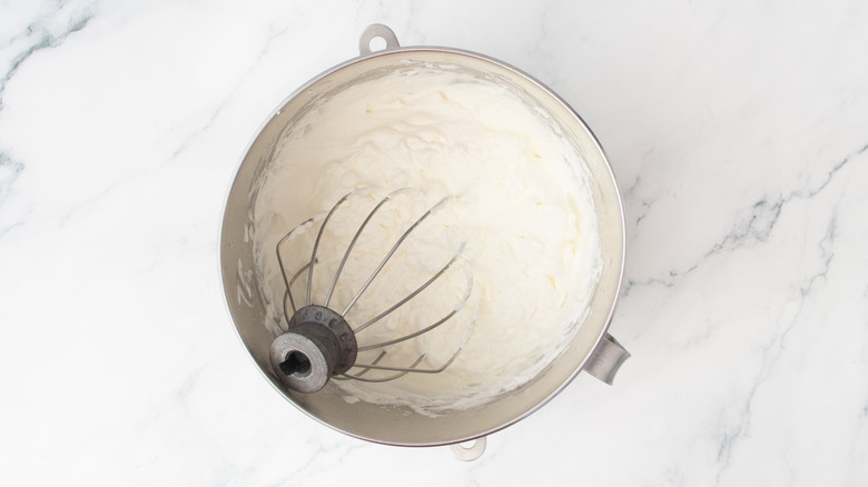 Whipped cream in bowl with whisk attachment