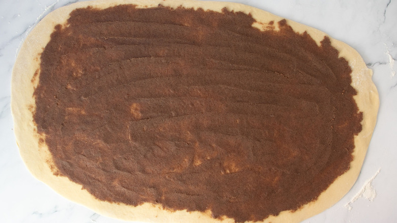 Cinnamon filling spread out over dough
