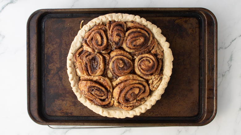 Baked cinnamon roll pie on baking sheet