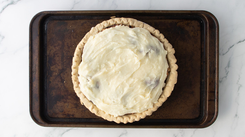 Frosted cinnamon roll pie on baking sheet