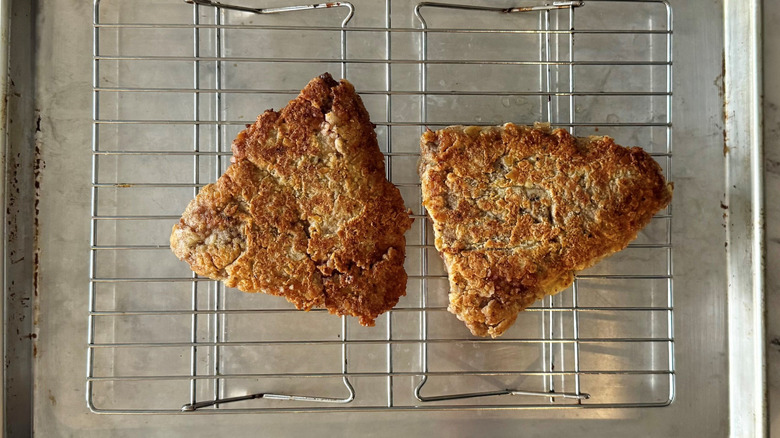 Browned steaks sitting on wire rack