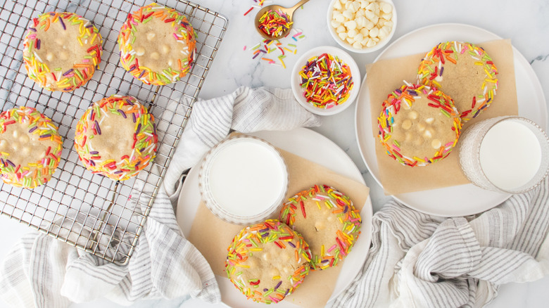 Copycat Crumbl blondie cookies with colorful sprinkles on wire rack and plates