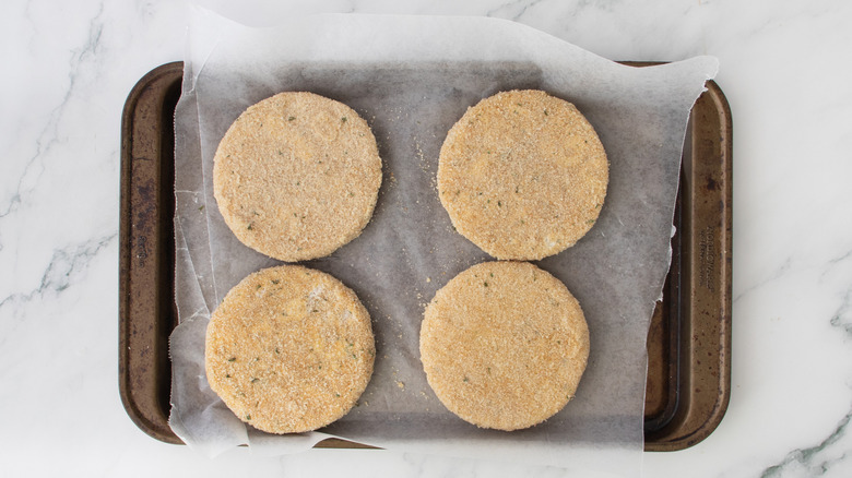breaded cheese patties on baking sheet