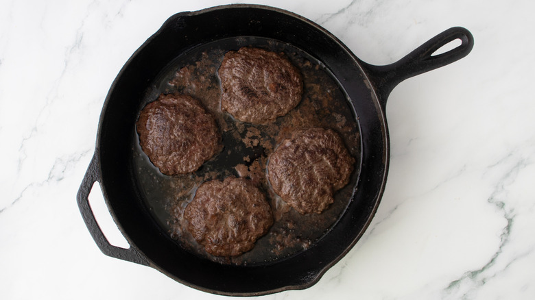 browned patties cooking in skillet