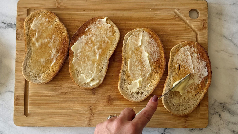 Spreading butter onto pieces of rye bread