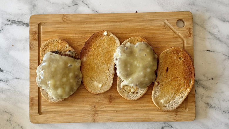 Open faced patty melts on wooden board