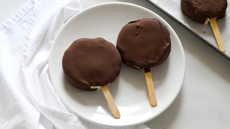 Two chocolate dilly bars sitting on a white plate
