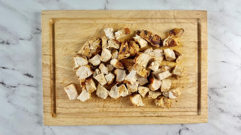 Cubed chicken on wooden board