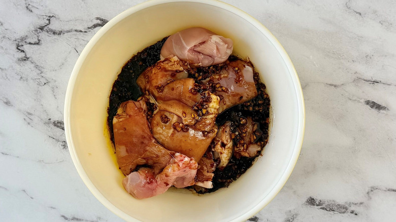 Chicken and marinade in bowl