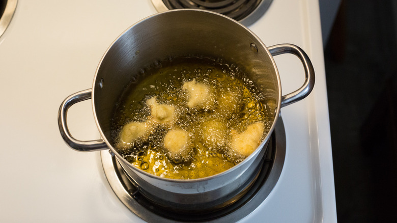 dough frying in medium pot