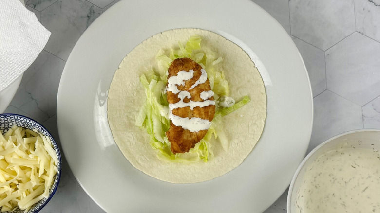 Chicken tender with ranch and lettuce on tortilla