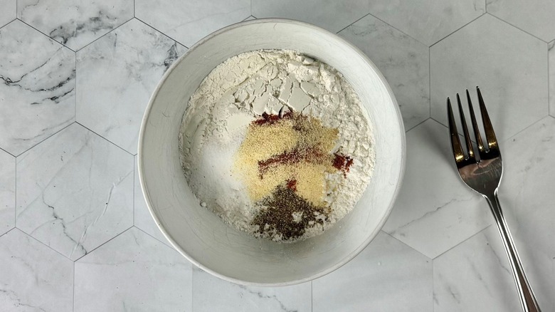 Flour and seasonings in bowl next to fork